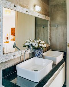 y baño con lavabo y espejo. en Casa Grega, en Arraial do Cabo
