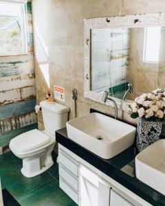 a bathroom with a toilet and a sink and a mirror at Casa Grega in Arraial do Cabo +28 photos