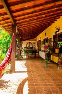 un patio al aire libre con techo de madera y mesa en Aconchego Itaipava, en Petrópolis