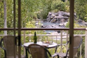 uma mesa e cadeiras em frente a uma cascata em Paradise Links Resort Port Douglas em Port Douglas