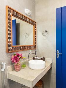 a bathroom with a sink and a mirror at Casa Santorini Terrace in Arraial do Cabo