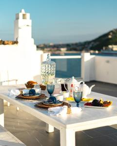 una mesa blanca con comida en la parte superior de un balcón en Casa Santorini Terrace en Arraial do Cabo