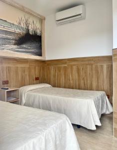 チクラナ・デ・ラ・フロンテーラにあるHostal Noliのベッド2台とエアコンが備わる客室です。