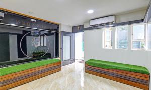 a living room with green cushions and a large window at Itsy By Treebo - Kings L Den Homestay in Mysore