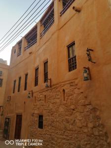 an old building with windows on the side of it at Bait Baityn بيت البيتين in Misfāh