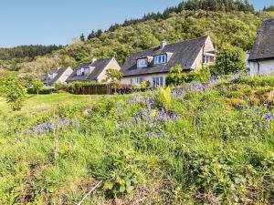 a group of houses on a hill with purple flowers at Shoreline in Connel