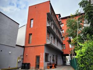 pomarańczowy budynek z balkonem przy ulicy w obiekcie Vila Dorobantilor w Klużu-Napoce