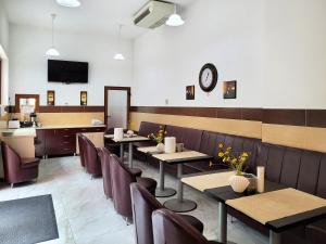 Vila Dorobantilor في كلوي نابوكا: مطعم بطاولات وكراسي وساعة على الحائط