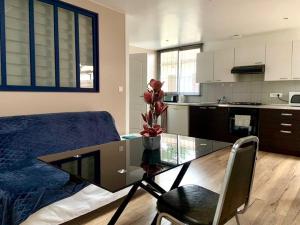 a bedroom with a glass table and a kitchen at Maisonnette Bassin d'Arcachon in La Teste-de-Buch