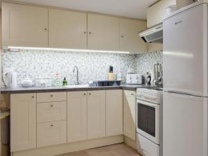 a kitchen with white cabinets and white appliances at The Wee Hoose in Kinghorn