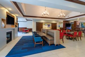 a hotel lobby with a fireplace and tables and chairs at Holiday Inn Express State College at Williamsburg Square, an IHG Hotel in State College