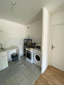 uma cozinha com uma máquina de lavar roupa e uma máquina de lavar roupa em Grand appartement entier situé à aulnay-sous-bois em Aulnay-sous-Bois