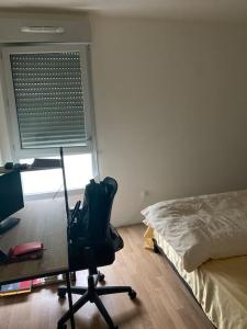 um quarto com uma secretária e uma cadeira ao lado de uma cama em Grand appartement entier situé à aulnay-sous-bois em Aulnay-sous-Bois