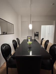 a conference room with a black table and chairs at Altstadt Apartment, 15 zur Messe in Düsseldorf