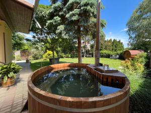 a small pond in a wooden circle in a yard at Abigél Vendégház Keszthely in Keszthely