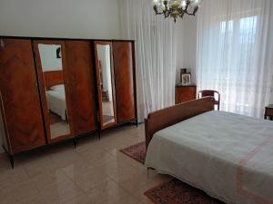 a bedroom with a bed and a dresser with a mirror at La CASA degli IPPOCASTANI in Colonnella