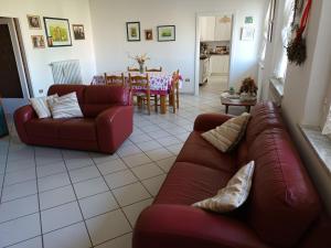 una sala de estar con 2 sofás rojos y una mesa. en La CASA degli IPPOCASTANI, en Colonnella