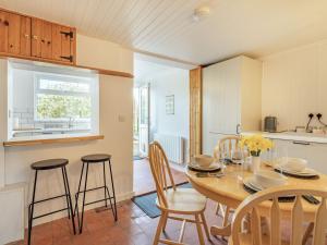 a kitchen and dining room with a table and chairs at Keepers Cottage in Grimston