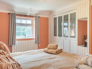 a bedroom with a bed with a stuffed animal on it at Keepers Cottage in Grimston