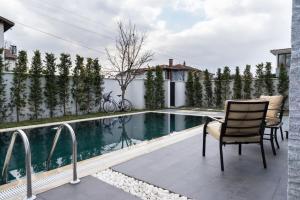 a patio with two chairs and a swimming pool at Narev Kırkpınar Sapanca in Sapanca