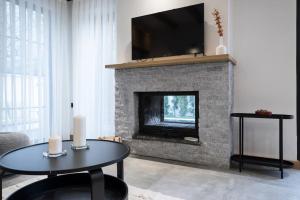 a living room with a fireplace with a flat screen tv at Narev Kırkpınar Sapanca in Sapanca