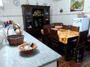 a kitchen with a counter and a table with chairs at CASA DA ALDEIA - Ponte de Sor (Alentejo) in Ponte de Sor