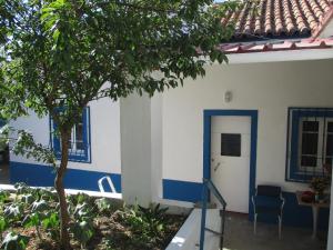 une maison avec des murs bleus et blancs et un arbre dans l'établissement CASA DA ALDEIA - Ponte de Sor (Alentejo), à Ponte de Sor