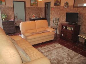 - un salon avec un canapé et une télévision dans l'établissement CASA DA ALDEIA - Ponte de Sor (Alentejo), à Ponte de Sor