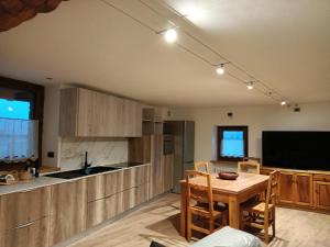 a kitchen and dining room with a table and a television at Le temps Retrouvé - casa tipica con giardino in Villeneuve