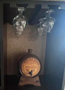 une horloge et deux verres sur un mur dans l'établissement Edem B&B, à Sevan