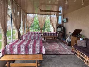 a bedroom with two beds and a couch and a tv at Edem B&B in Sevan