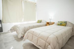 sypialnia z 2 łóżkami i oknem w obiekcie Cabañas El Aby w mieście El Bolsón
