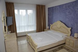 a bedroom with a bed and a blue wall at Apartament Corso in Turda