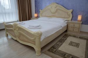 a bedroom with a large bed with white sheets and towels at Apartament Corso in Turda