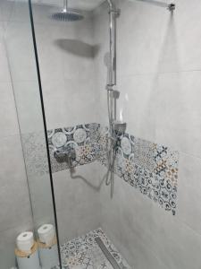 a bathroom with a shower with tiles on the wall at STUDIO 33 in Šabac