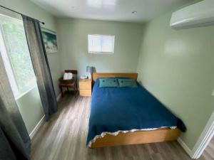 - une chambre avec un lit doté d'une couverture bleue dans l'établissement Hidden Gem LA: 2bd guesthouse w/ dreamy backyard, à Encino