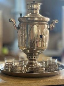 a silver tea kettle and glasses on a plate at Edem B&B in Sevan
