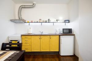 a kitchen with yellow cabinets and a microwave at Mereranna apartment 5 in Kuressaare