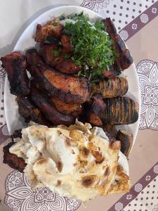 a plate of food with sausages and meat on a table at Edem B&B in Sevan