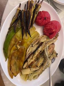 un plato de comida con carne y verduras en una mesa en Edem B&B en Sevan