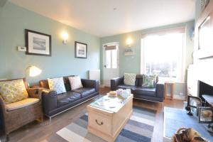 a living room with couches and a coffee table at 6 Coastguard Cottages, Aldeburgh in Aldeburgh