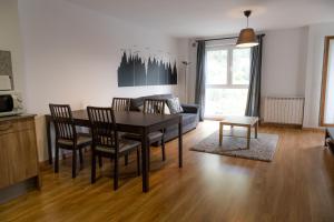 ein Wohnzimmer mit einem Tisch und einem Sofa in der Unterkunft Apartamento moderno El Bosque en Arinsal in Arinsal