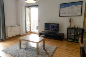 a living room with a coffee table and a tv at Apartamento moderno El Bosque en Arinsal in Arinsal