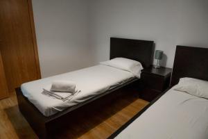 a small bedroom with two beds with white sheets at Apartamento moderno El Bosque en Arinsal in Arinsal