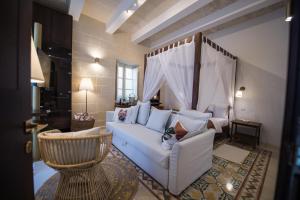 a living room with a white couch and a chair at Casa Maria Tereza in Cospicua