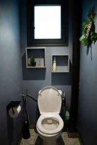 een badkamer met een wit toilet en een raam bij Le Bambou T3 Centre ville Sainte Clotilde Rez de jardin in Bois de Nèfles