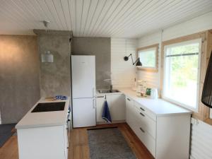 uma cozinha com armários brancos e um frigorífico branco em Private Lakeside Holiday Property in Nature em Kankaanpää