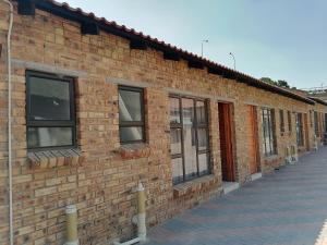 a brick building with windows on the side of it at Lukhanya Guesthouse in Randfontein
