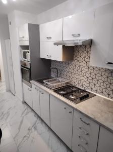 una cucina con armadi bianchi e piano cottura di Apartament Czeladź 60m2 Centrum Katowic 10km a Czeladź