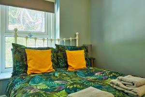 a bedroom with a bed with yellow pillows and a window at Finest Retreats - Peak View in Two Dales